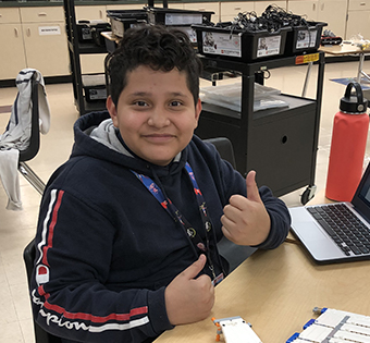 student working on a computer giving a thumbs up